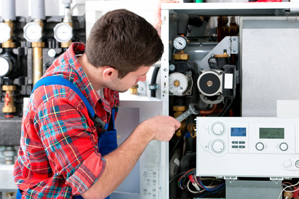 HVAC technician inspecting and repairing boiler controls in Pleasant Grove