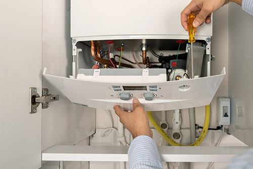 HVAC technician repairing an indoor boiler in Pleasant Grove