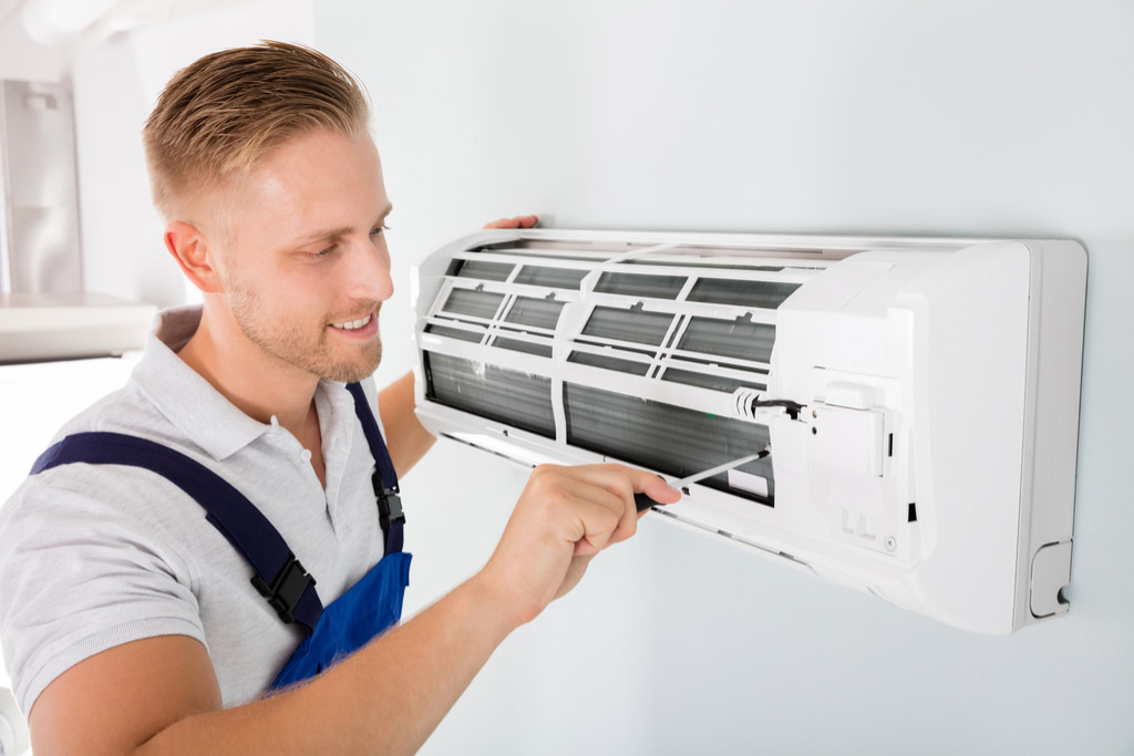 HVAC technician performing ductless air conditioning maintenance in Pleasant Grove