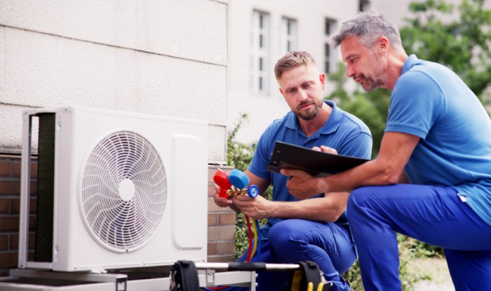 HVAC technicians installing an outdoor air conditioning unit in Pleasant Grove