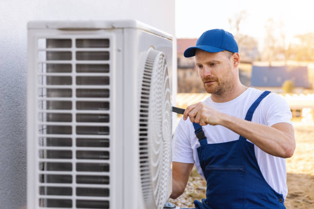 HVAC technician servicing an outdoor air conditioning unit in Pleasant Grove