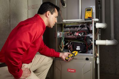 Heating and air conditioning technician servicing an indoor furnace in Pleasant Grove, UT